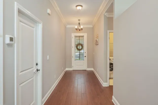 a view of a hallway with wooden floor and a bathroom