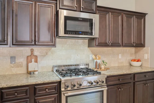 a kitchen with granite countertop a stove top oven cabinetry and granite counter tops