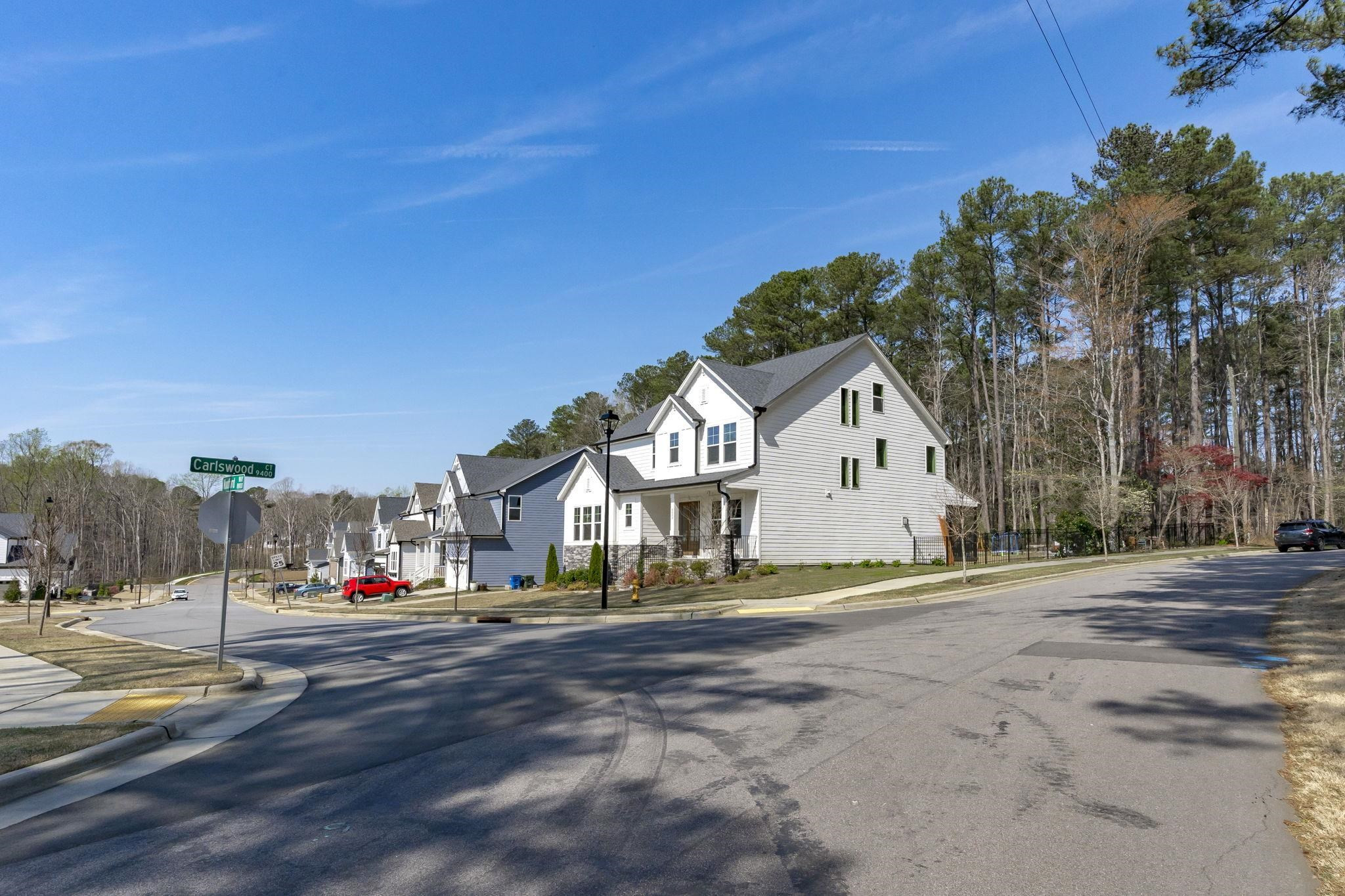 12801 Strickland Road Raleigh, NC 27613 - Photo 23 of 27 a view of white house with a big yard and large trees
