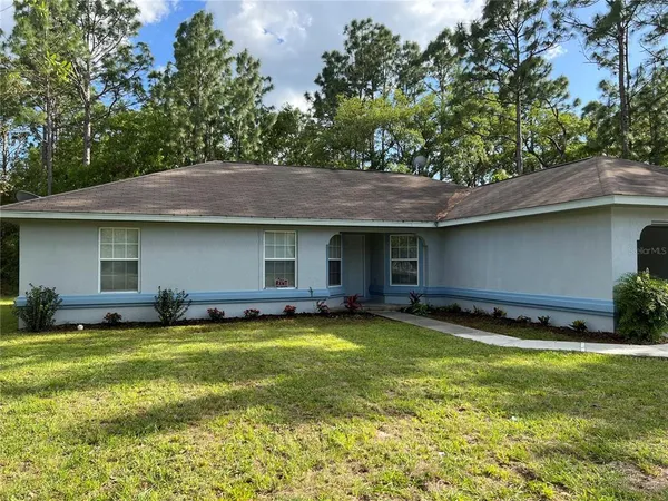 a view of a house with a yard and a patio
