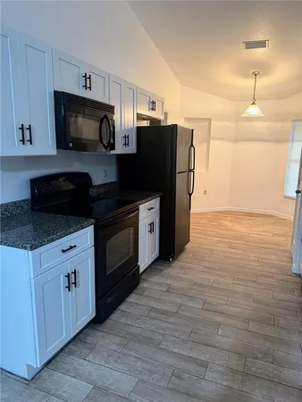a kitchen with stainless steel appliances granite countertop a refrigerator stove and microwave