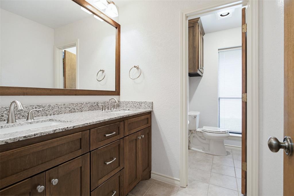 2905 Valleyview Drive Grapevine, TX 76051 - Photo 11 of 12 a bathroom with a granite countertop sink and a mirror