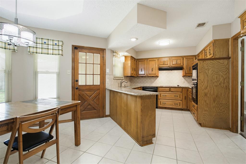 2905 Valleyview Drive Grapevine, TX 76051 - Photo 6 of 12 a kitchen with kitchen island a counter top space appliances and a window