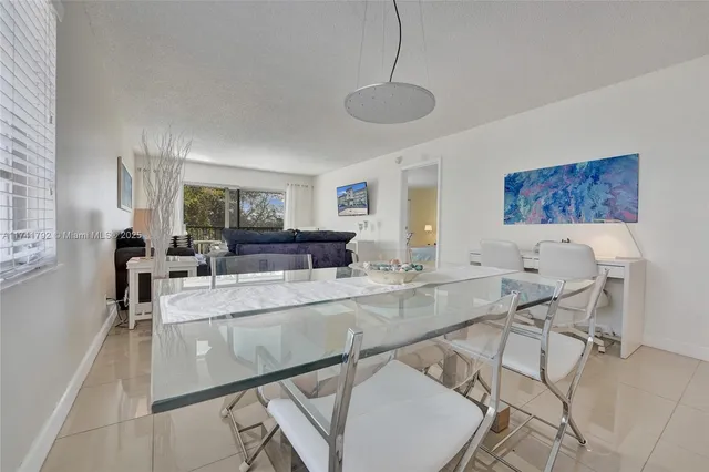 a view of a dining room and livingroom with furniture wooden floor a chandelier