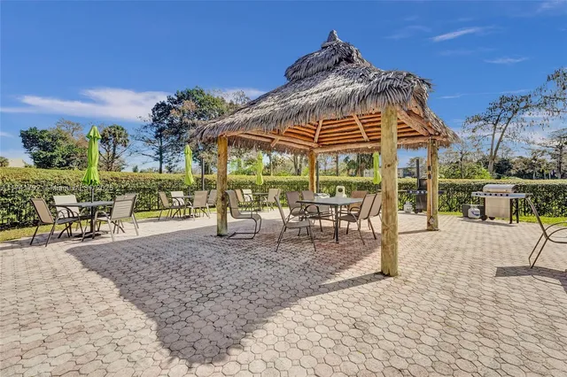 a swimming pool with outdoor seating and yard in the back