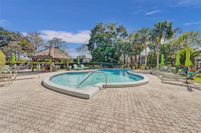 a view of a patio with a table and chairs under an umbrella with a garden