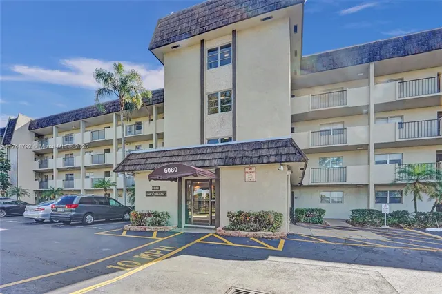 a front view of a building with parking space and windows