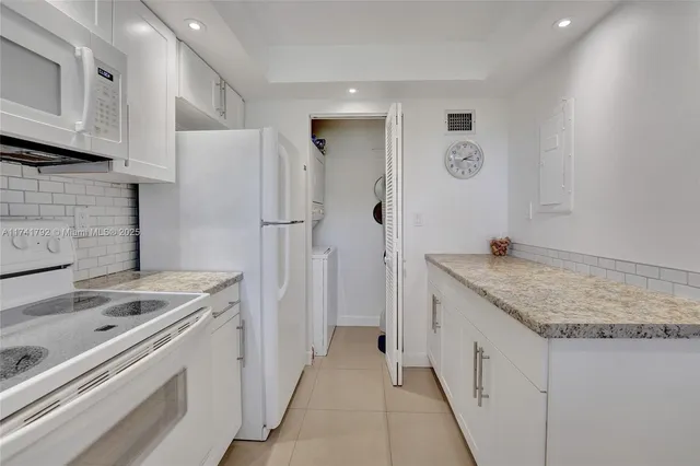 a kitchen with granite countertop a sink stove and refrigerator