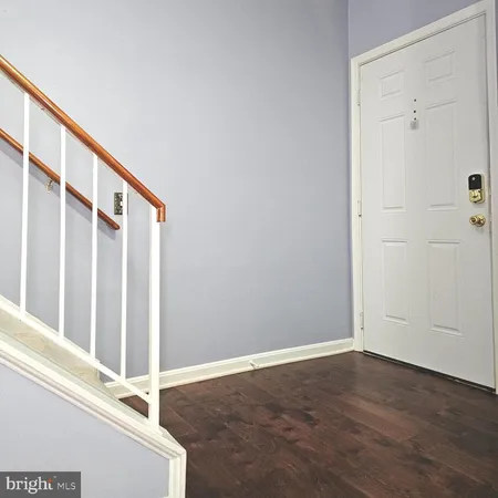 a view of staircase with white walls and white door