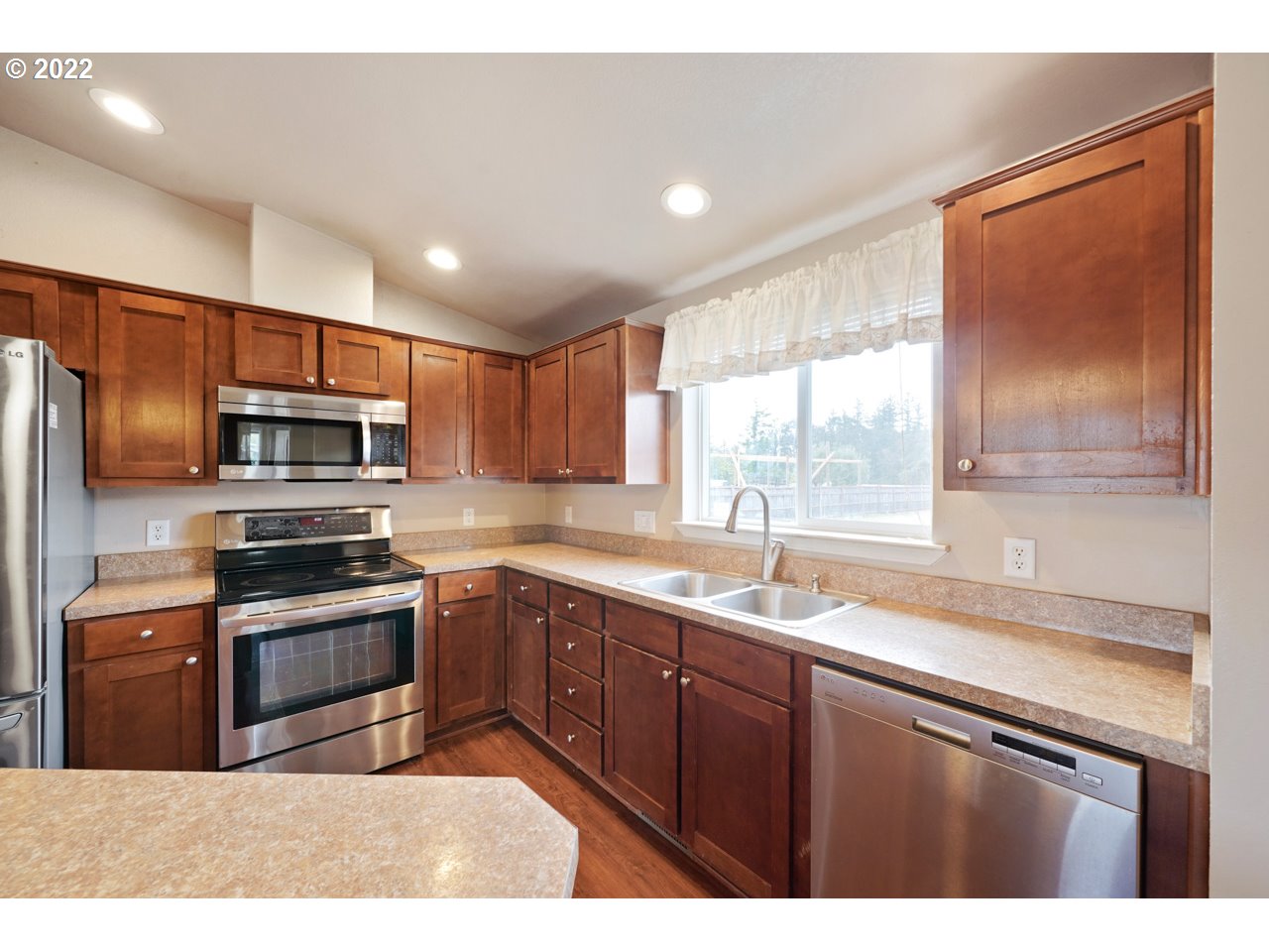6028 Stayton Road Southeast Turner, OR 97392 - Photo 7 of 29 a kitchen with stainless steel appliances granite countertop a sink a stove a refrigerator cabinets and a window