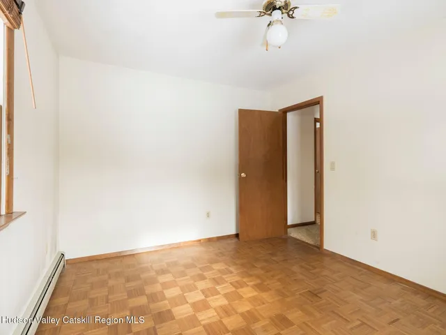 a view of a room with wooden floor and ceiling fan