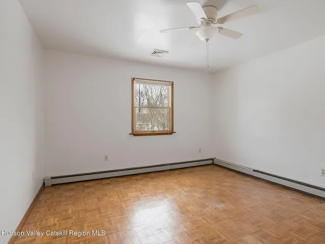 an empty room with a ceiling fan and window