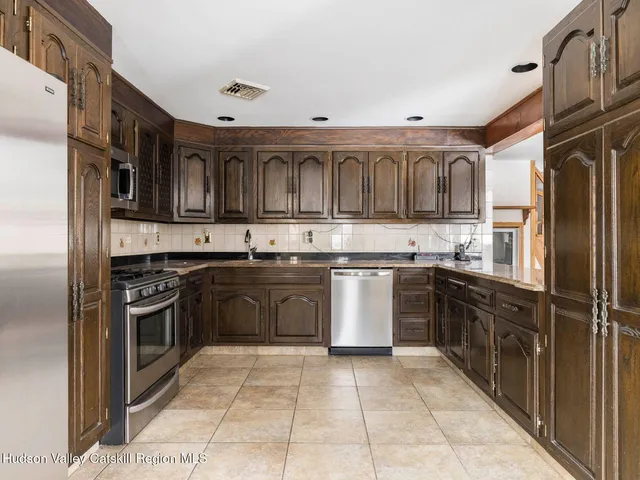 a kitchen with stainless steel appliances granite countertop a stove top oven a sink and dishwasher