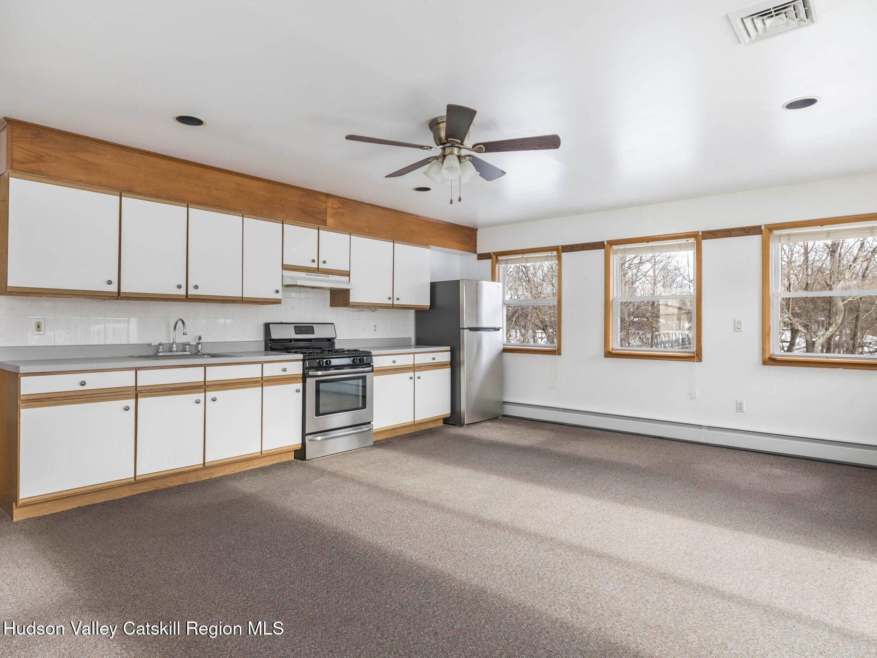 463 Mckinstry Road Gardiner, NY 12525 - Photo 41 of 52 a kitchen with stainless steel appliances granite countertop a stove a sink and white cabinets with wooden floor