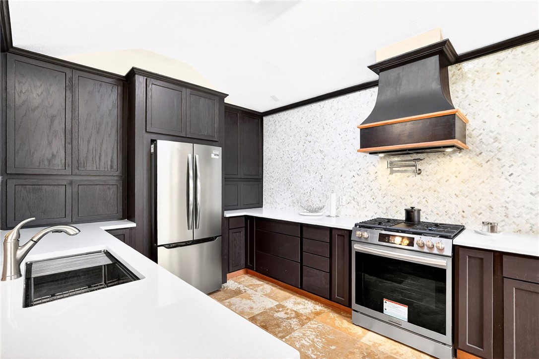 a kitchen with stainless steel appliances a stove a sink and a refrigerator
