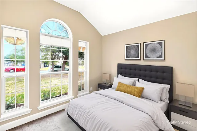 a bedroom with a bed and a large window