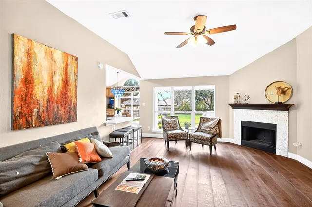 a living room with furniture floor to ceiling window and a fireplace