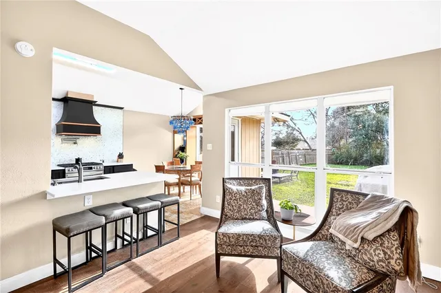 a dining room with furniture a rug and a floor to ceiling window