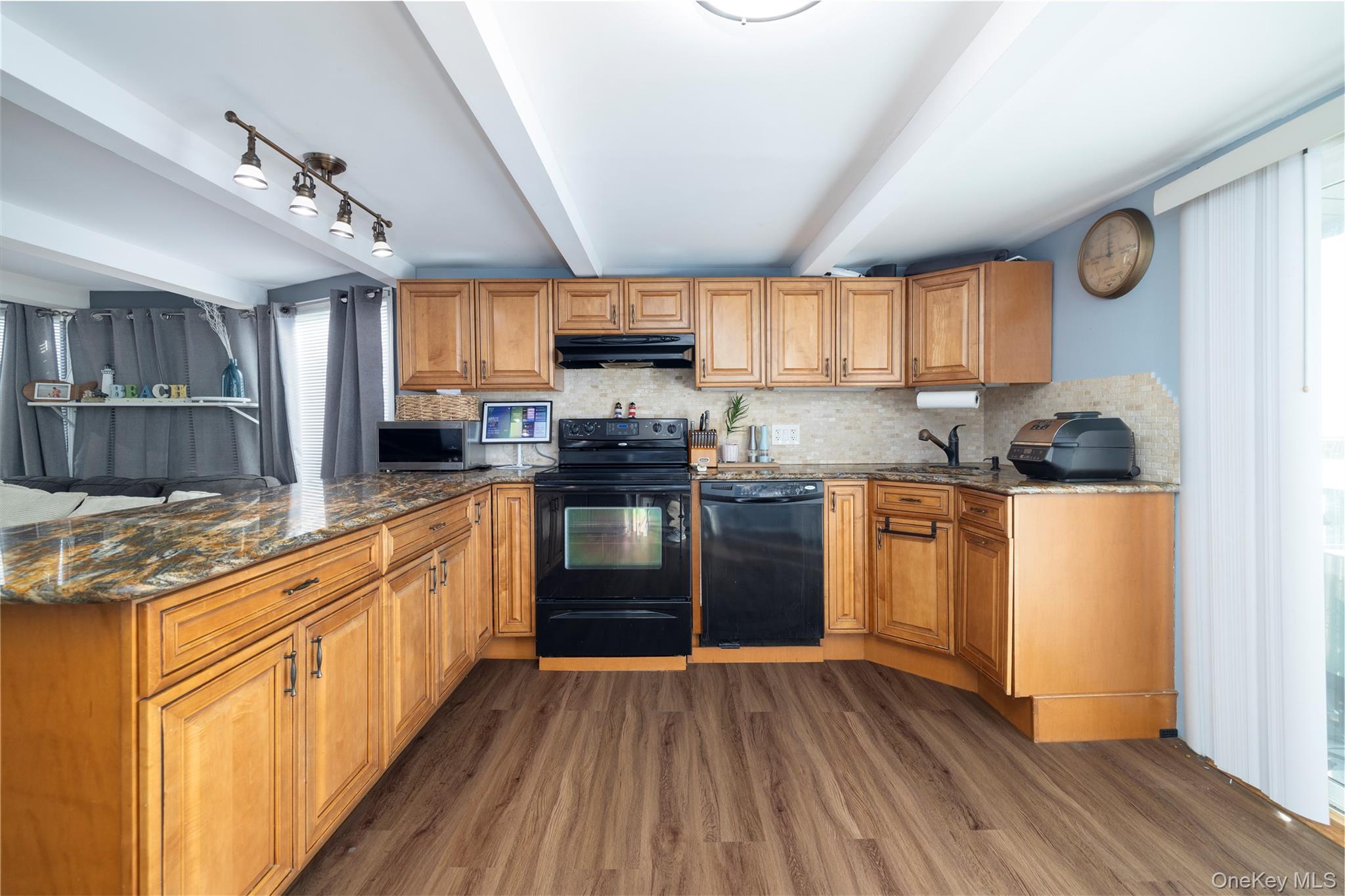 220 Shore Road Seaford, NY 11783 - Photo 11 of 23 a kitchen with stainless steel appliances granite countertop wooden cabinets a sink a stove a refrigerator and island with wooden floors