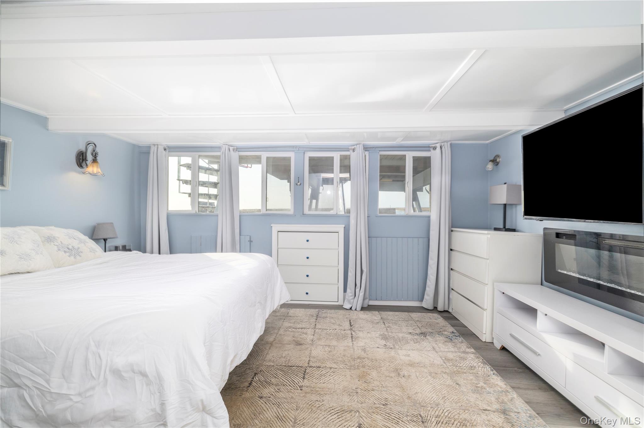 220 Shore Road Seaford, NY 11783 - Photo 14 of 23 a bedroom with a large bed and a flat screen tv