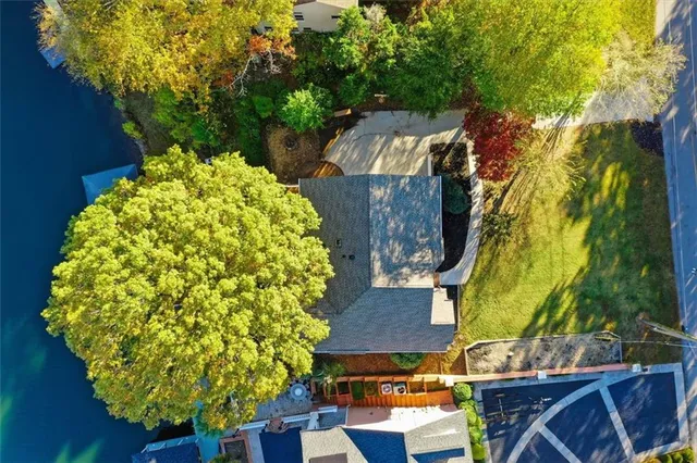 an empty room with wooden floor chandelier fan and windows