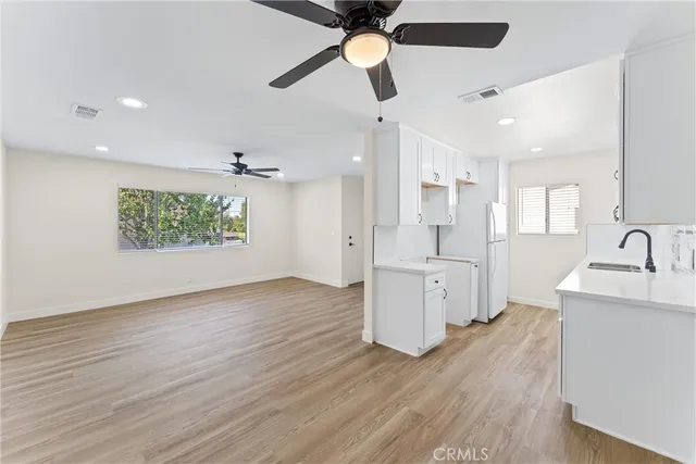 a view of an empty room and window a ceiling fan