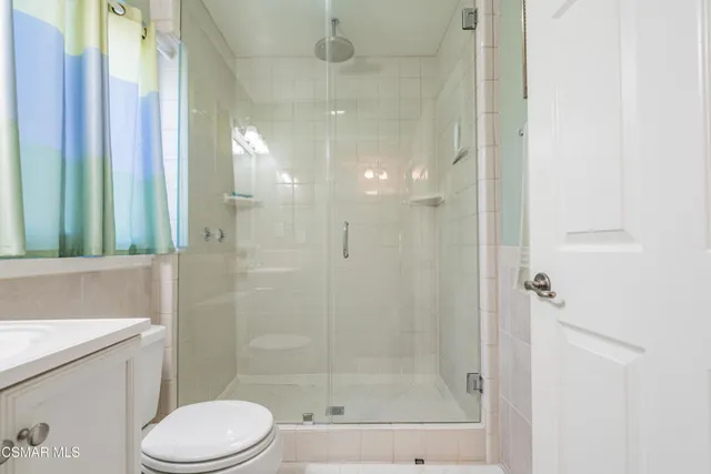 a bathroom with a shower a toilet and sink