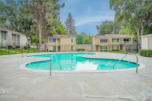 an aerial view of a house with a swimming pool and a yard