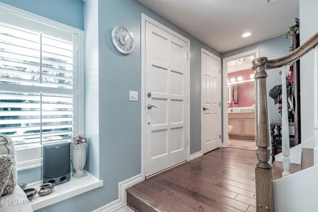 a view of a hallway with workspace and a window