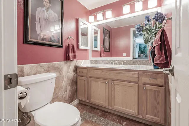 a bathroom with a toilet a sink and mirror