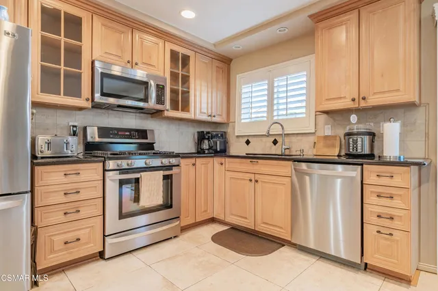 a kitchen with stainless steel appliances granite countertop a stove microwave and cabinets