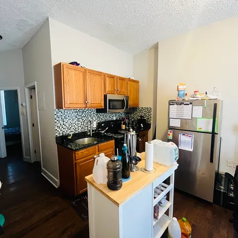 a kitchen with a refrigerator and a stove top oven
