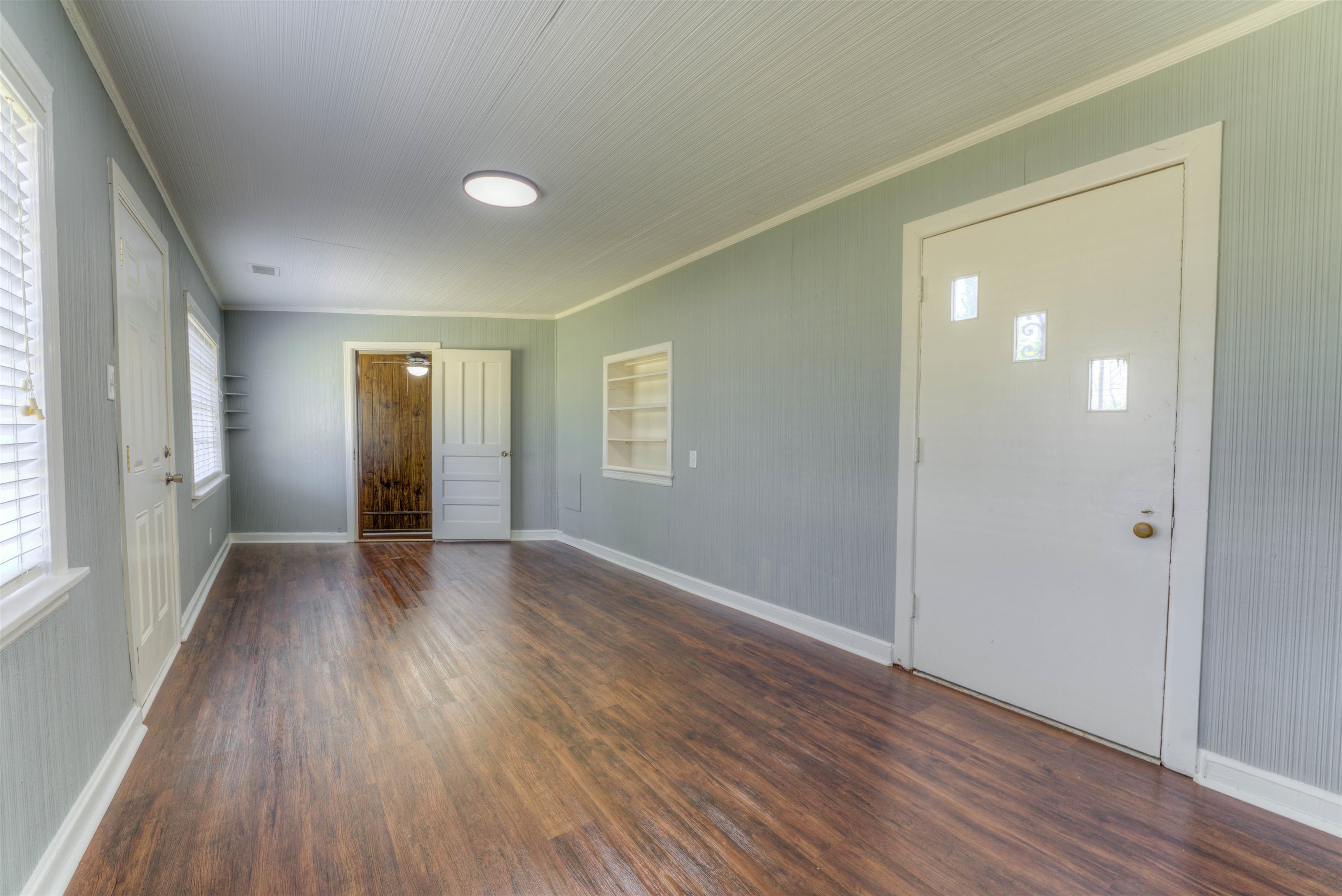 1180 Vaughn Road Memphis, TN 38122 - Photo 8 of 26 a view of an empty room with wooden floor and a window