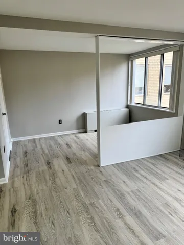 a view of a bedroom with wooden floor and windows