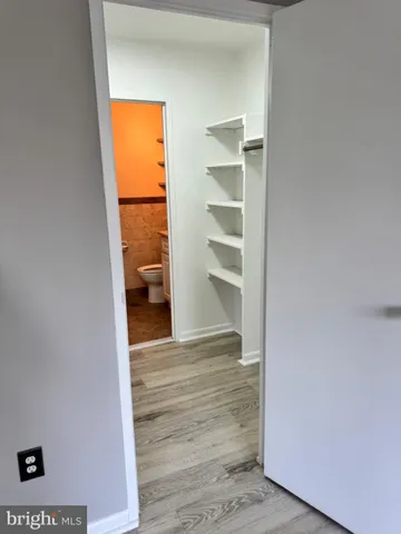 a view of walk in closet with wooden floor