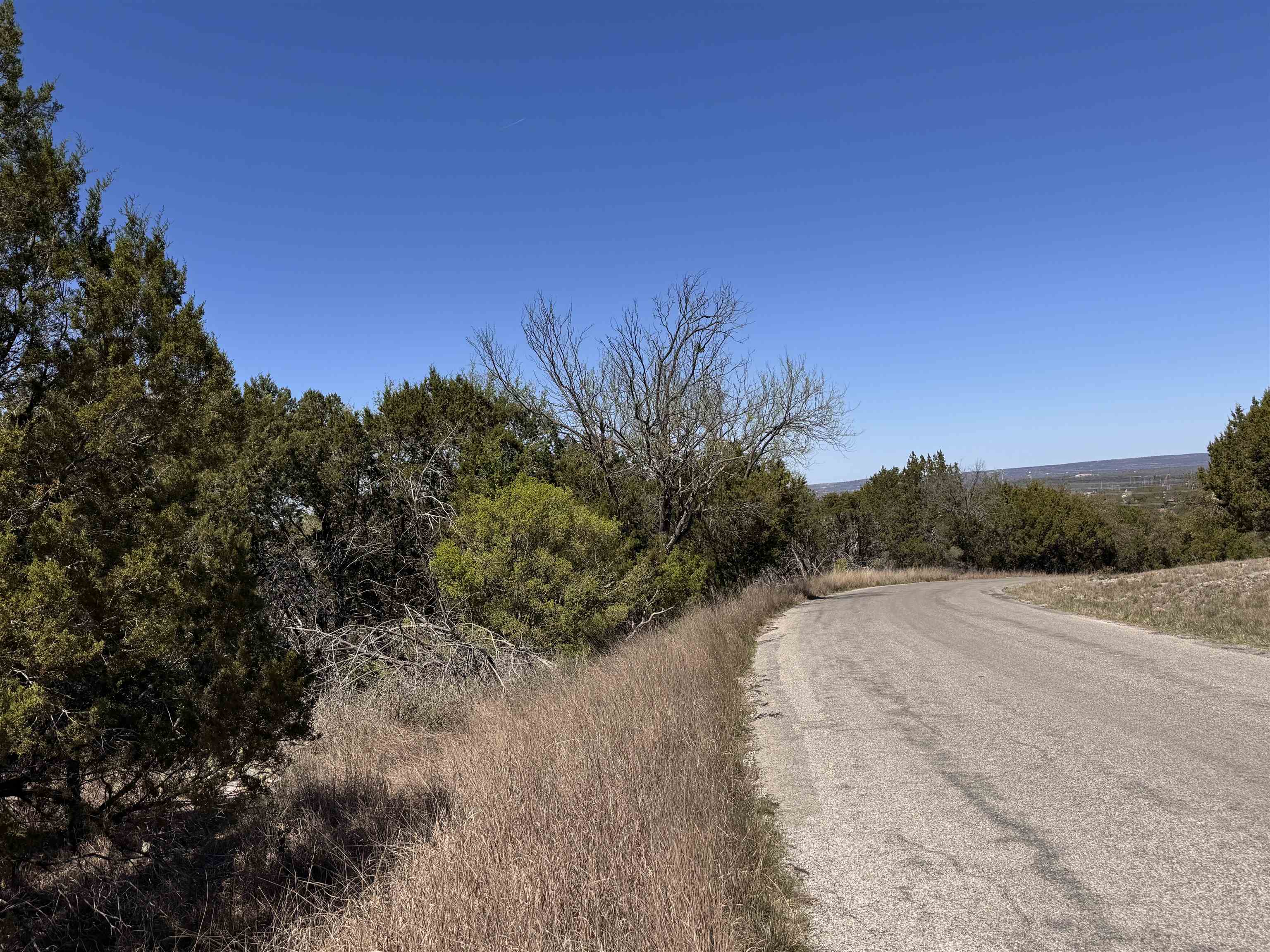 K11054 Mountain Dew Horseshoe Bay Tx 78657 Horseshoe Bay, TX 78657 - Photo 1 of 9 a view of a road with a yard