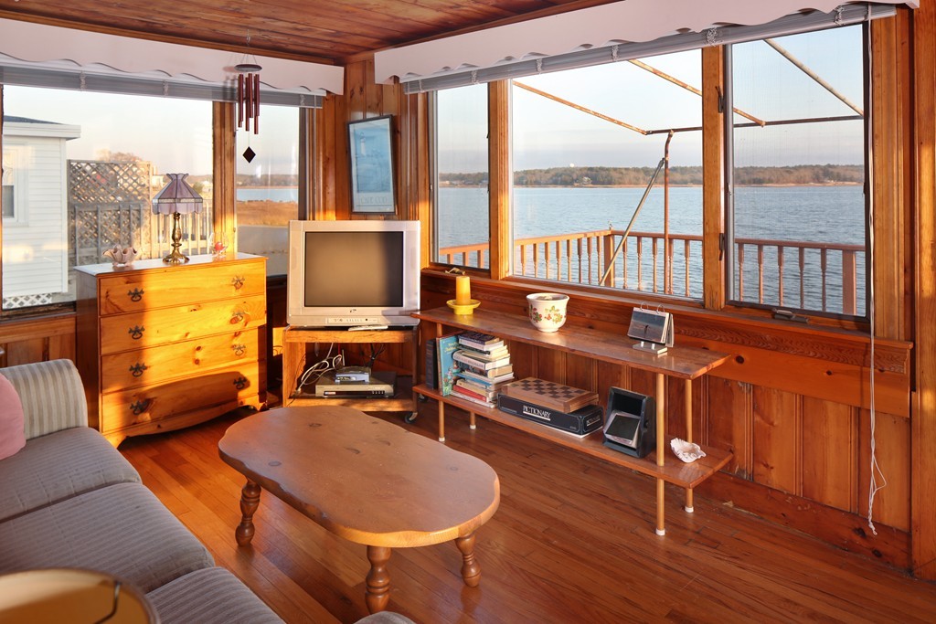 39 Beach Street Wareham, MA 02571 - Photo 16 of 24 a living room with furniture a flat screen tv and a floor to ceiling window