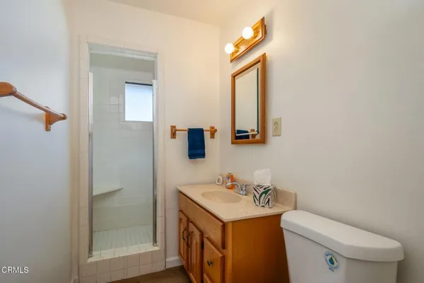 a bathroom with a toilet sink vanity and mirror