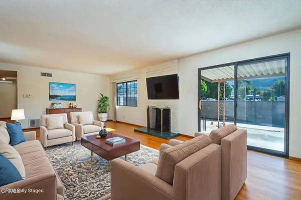 a living room with furniture a large window and a flat screen tv
