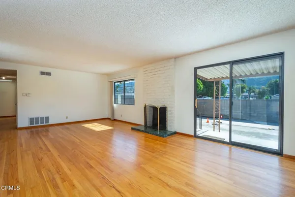 a view of empty room with wooden floor and floor to ceiling window
