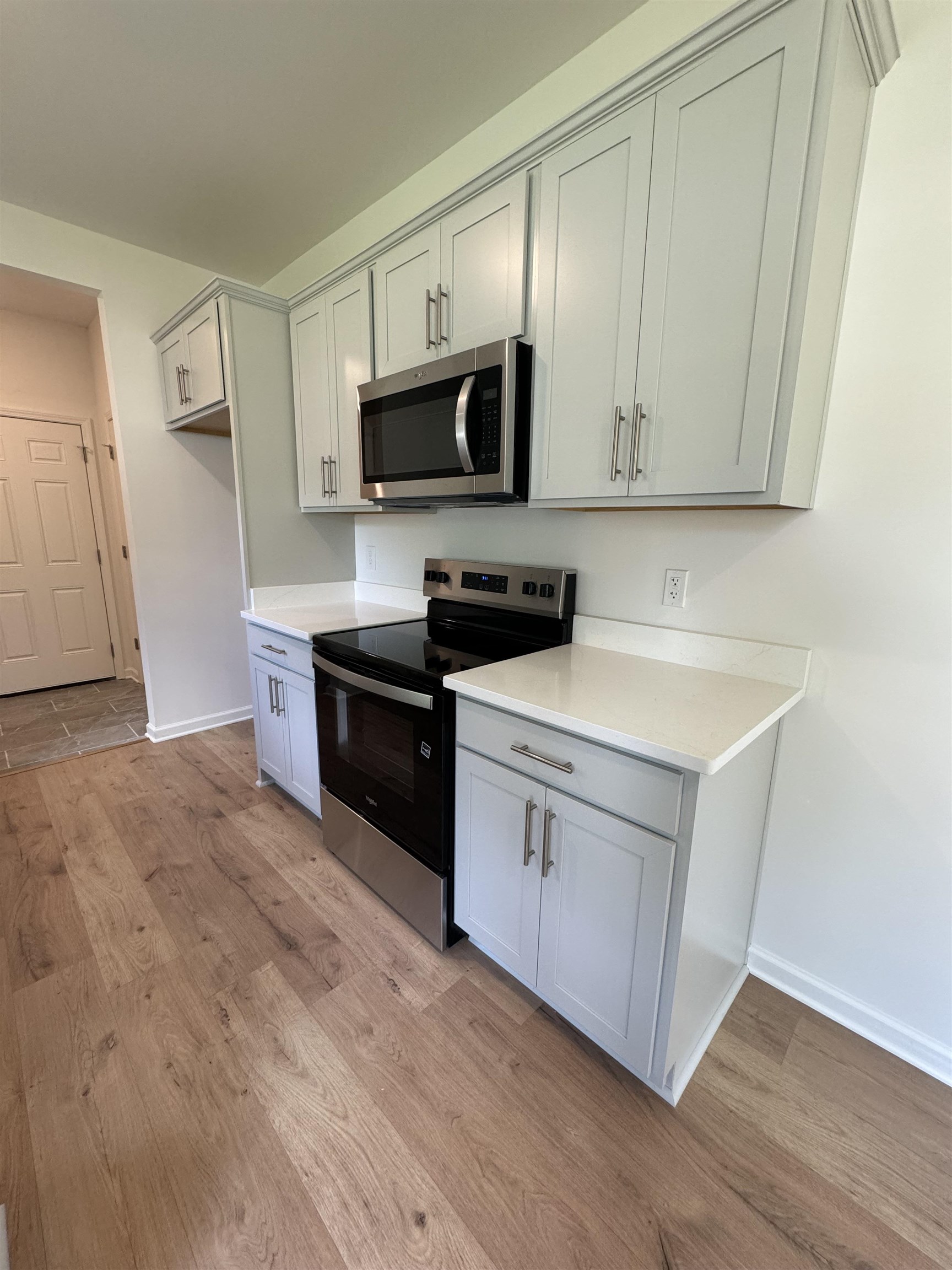 12370 South Main Street Somerville, TN 38068 - Photo 8 of 26 White countertops, wood-finish flooring, stainless steel appliances, light gray cabinetry, and crown molding