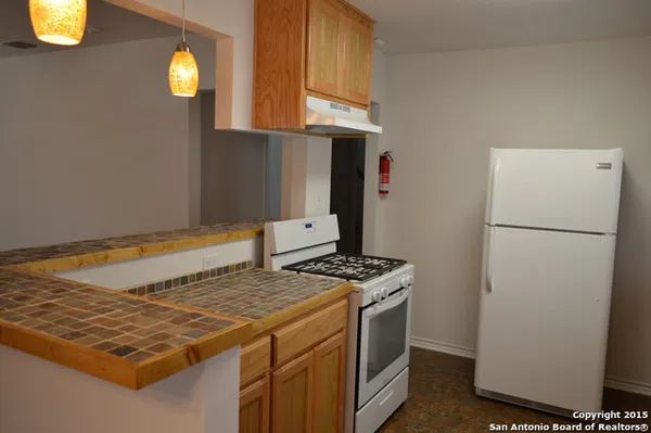 a kitchen with a stove and a refrigerator