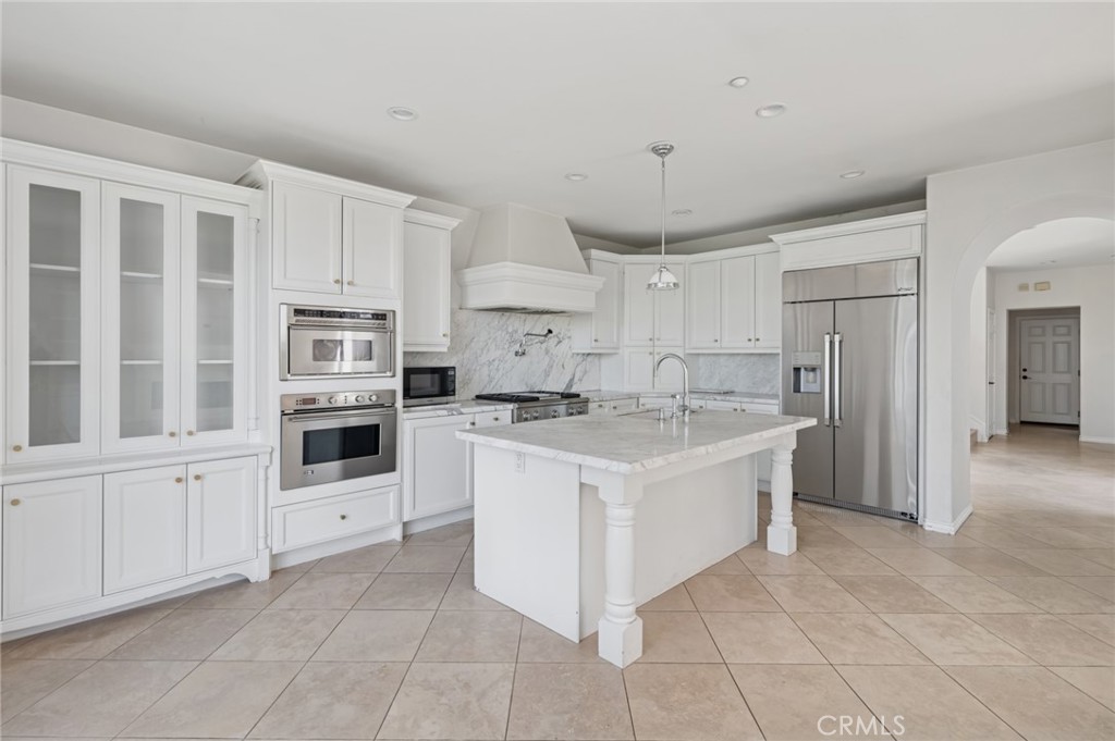4 Still Water Newport Coast, CA 92657 - Photo 11 of 43 a kitchen with white cabinets and stainless steel appliances