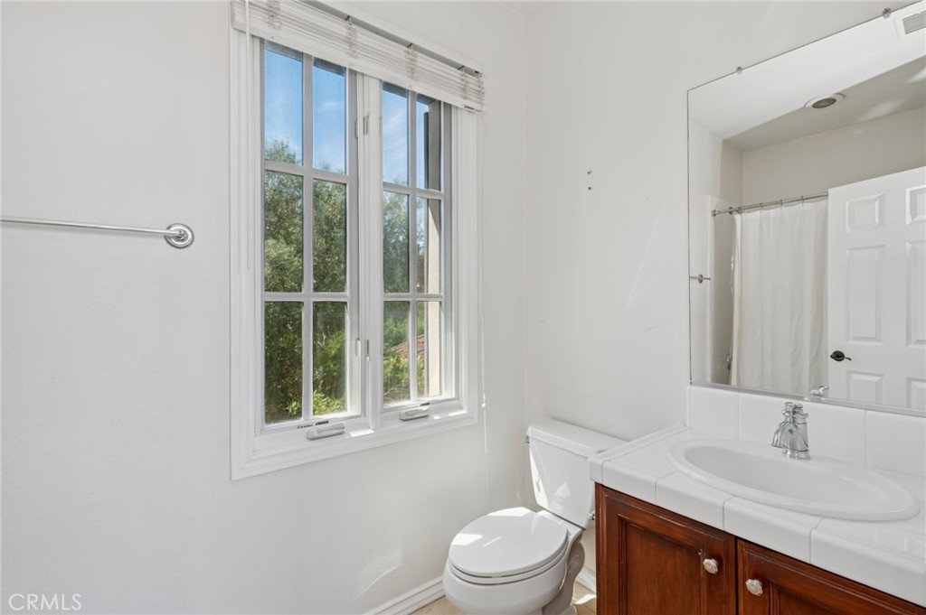 4 Still Water Newport Coast, CA 92657 - Photo 28 of 43 a bathroom with a granite countertop sink toilet a mirror and a window