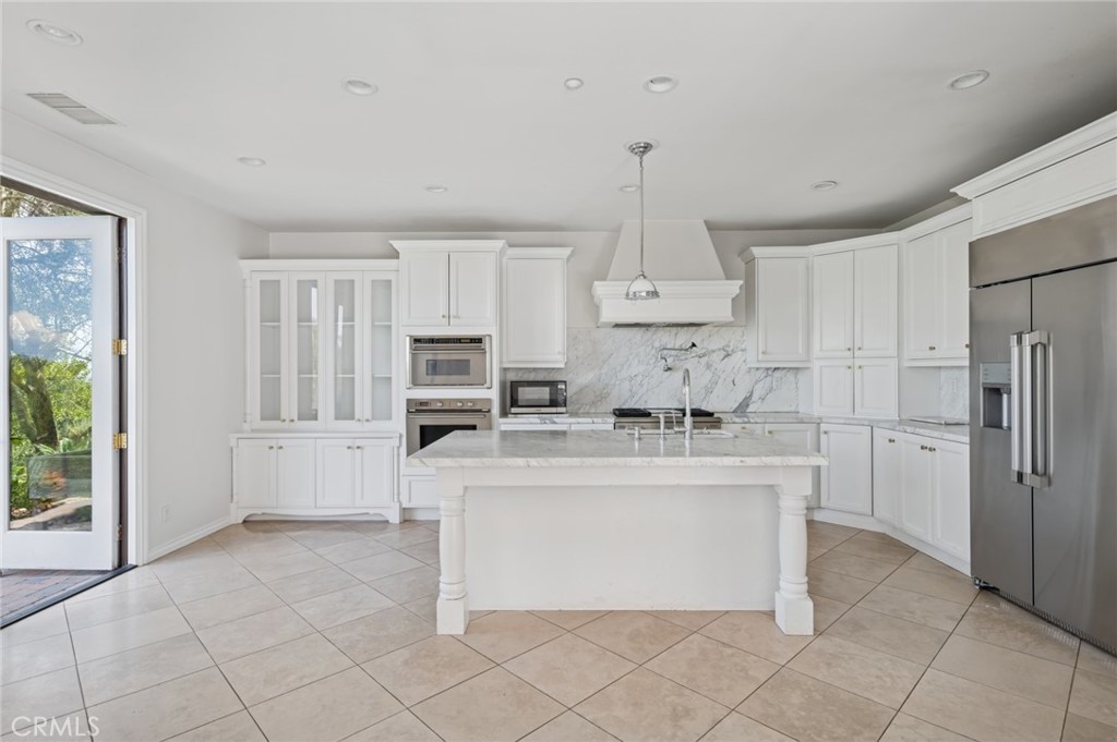 4 Still Water Newport Coast, CA 92657 - Photo 8 of 43 a kitchen with stainless steel appliances a refrigerator sink and cabinets