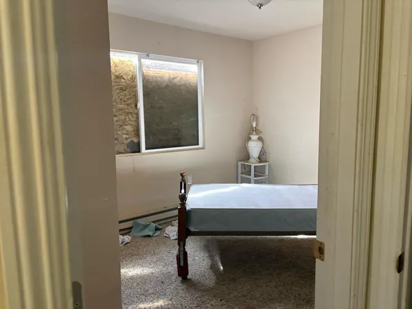 a view of a hallway with wooden cabinet and a bathroom