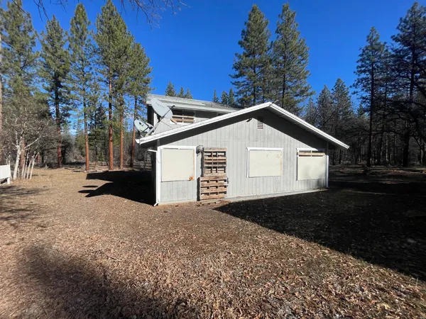 a view of a house with backyard and trees
