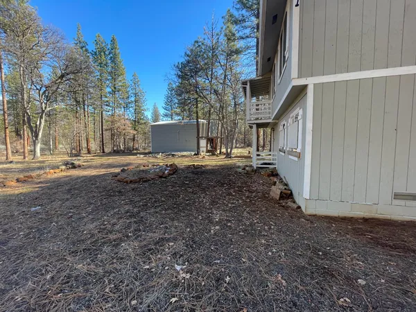a view of a house with backyard and trees