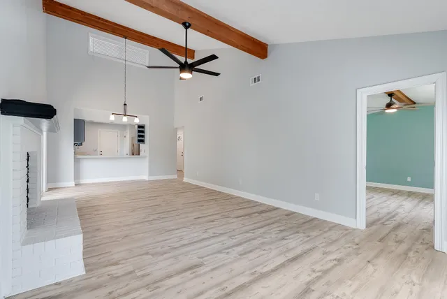 a view of empty room with wooden floor