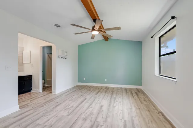 a view of a livingroom with wooden floor and a ceiling fan